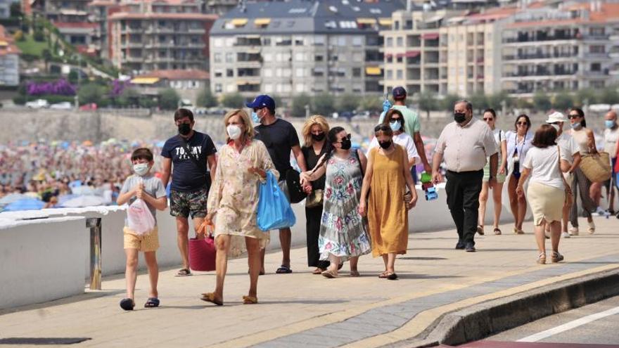 Turistas caminando por el paseo marítimo de Sanxenxo.