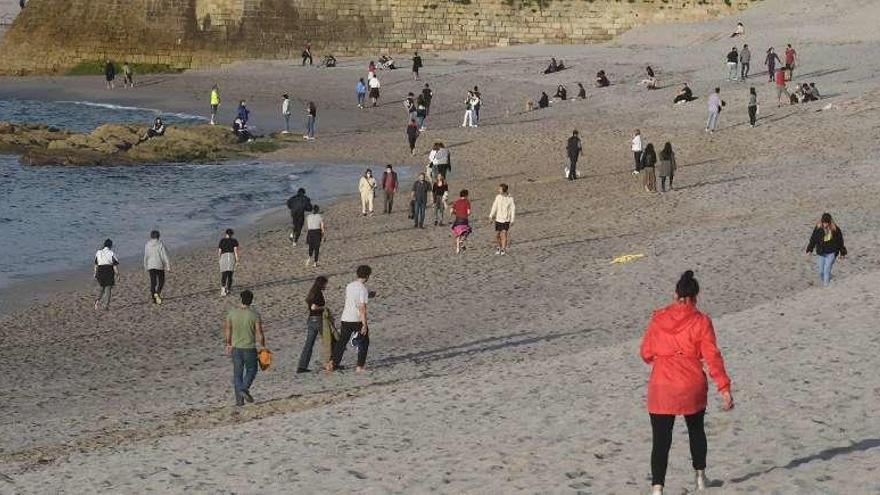 Personas paseando en la playa de Riazor durante el horario permitido durante el estado de alarma.