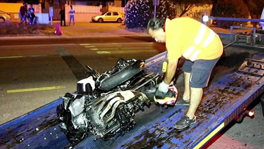 Un operario traslada en una grúa la moto de gran cilindrada donde viajaba la víctima.