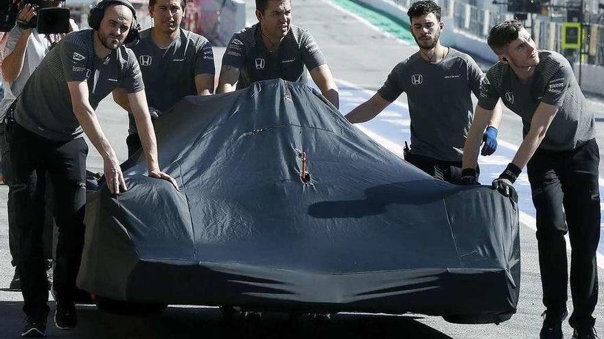 Los mecánicos empujan el coche de Alonso tras sufrir la avería. // Efe