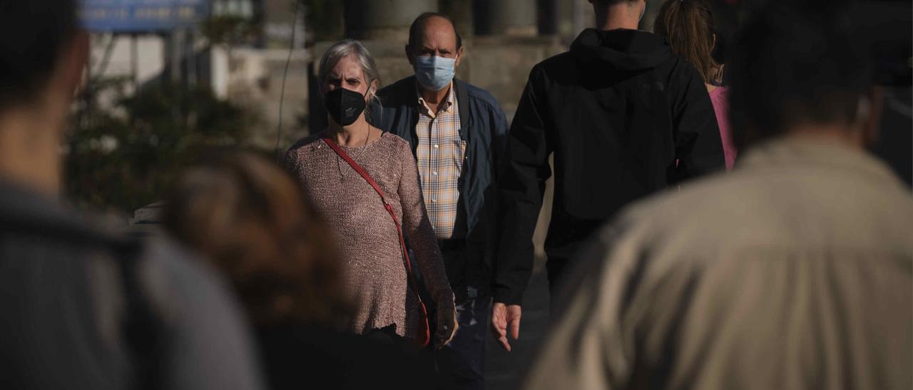 Un grupo de personas pasean en Santa Cruz de Tenerife con mascarilla para evitar el contagio de coronavirus.