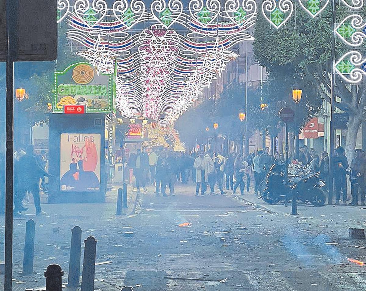 Ambiente fallero en una calle de Russafa, con restos de petardos en el suelo.