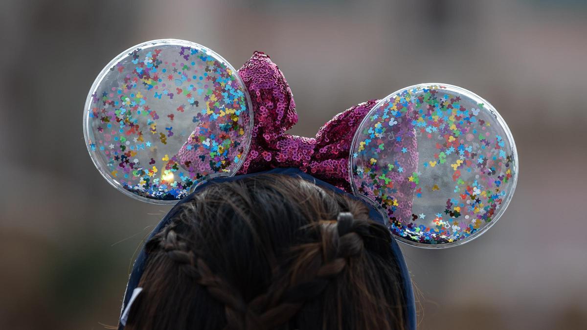 Una mujer con una diadema con las conocidas orejas de Mickey Mouse