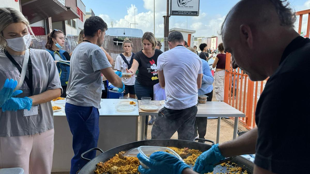 Reparto de paella en una nave de Cervezas Alegría en el polígono de Massanassa.