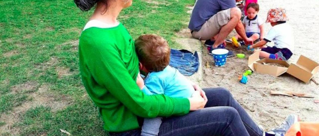 Una madre amamanta a su bebé en un parque de Madrid.