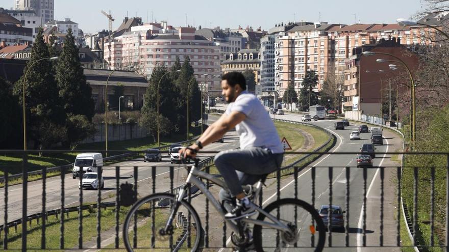 Un hombre pasea en bicicleta por Oviedo.