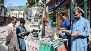 Vecinos de Muzaffarabad, la capital de la región de Cachemira administrada por Pakistán, leen los diarios tras la declaración de alto el fuego.