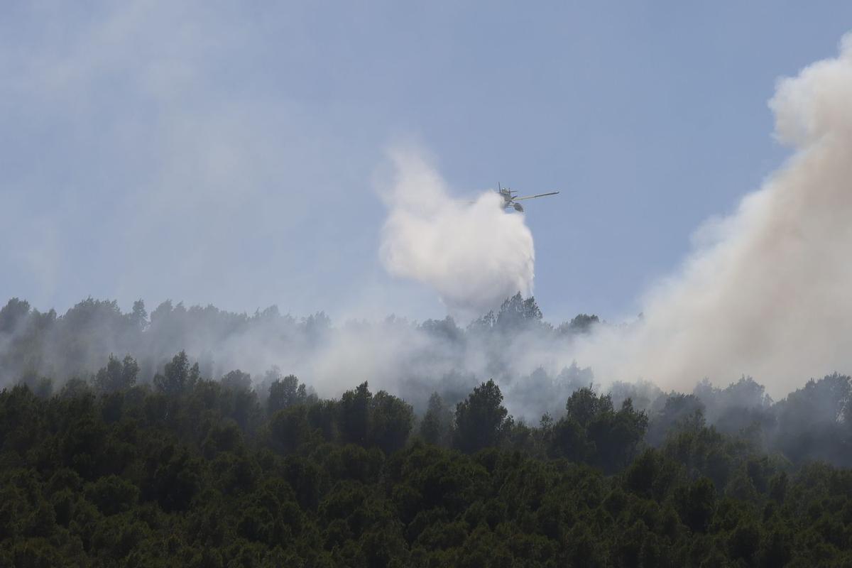 Un hidroavión descarga un aporte de agua para apagar las llamas del incendio de Tírig.