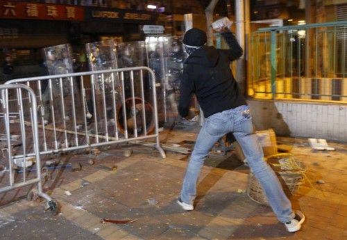 A protester throws a stone towards riot police at Mongkok district in Hong Kong