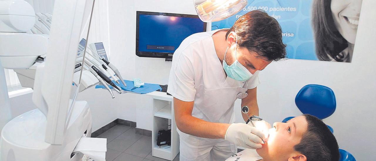 Un menor es atendido en la consulta del dentista para una revisión bucodental.