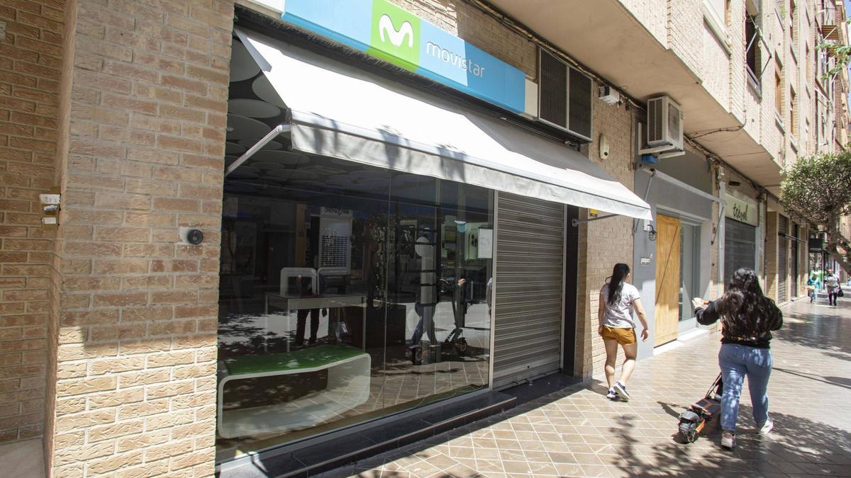 Dos mujeres pasan frente a la tienda de móviles donde tuvo lugar el robo.