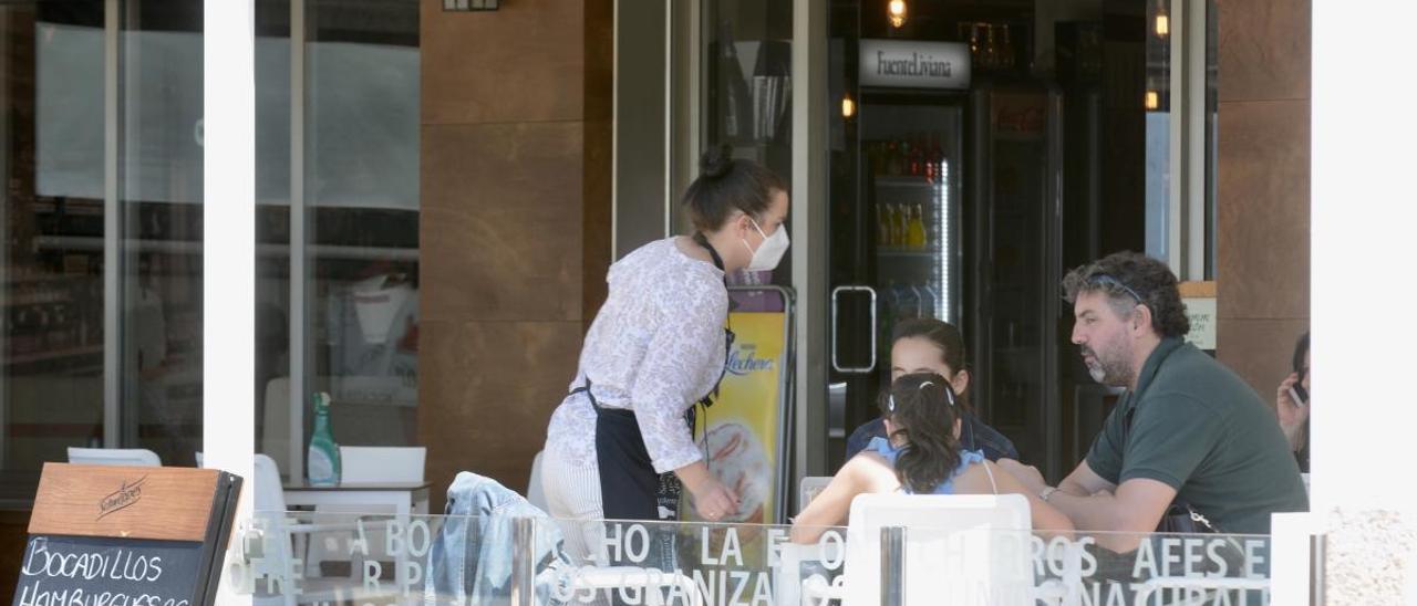 Una camarera atiende a unos clientes en una terraza de Sanxenxo. // Rafa Vázquez