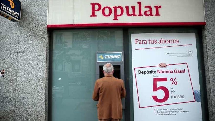 Un cliente en un cajero de una antigua sucursal del Popular en Madrid.