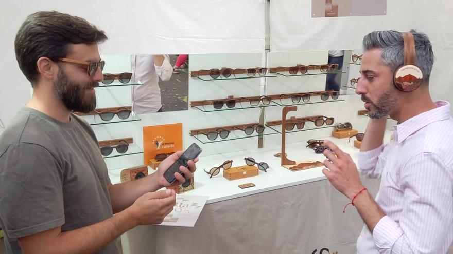 El concejal de Fiestas prueba los auriculares de madera para música que ganó el primer premio de Artesanía Contemporánea.