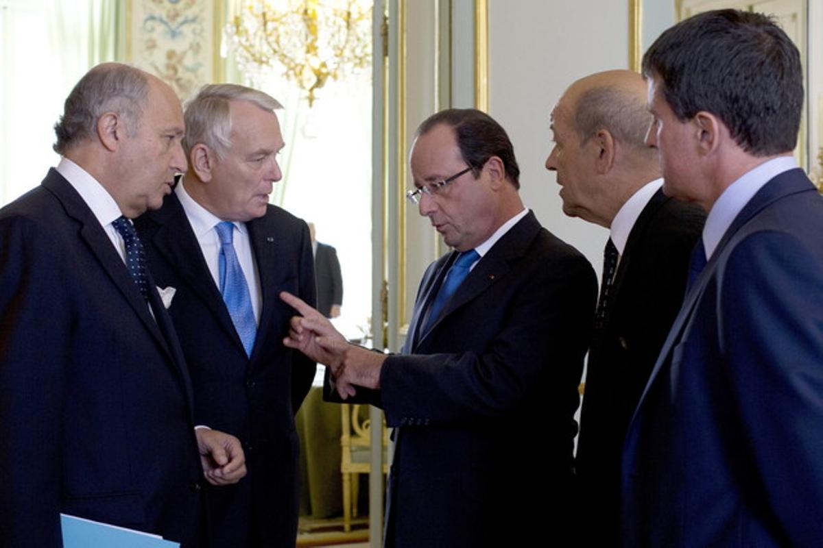 Hollande conversa amb els seus ministres Laurent Fabius (esquerra), Jean-Marc Ayrault (segon per l’esquerra), Jean-Yves Le Drian (segon per la dreta) i Manuel Valls (dreta), la setmana passada a l’Elisi.