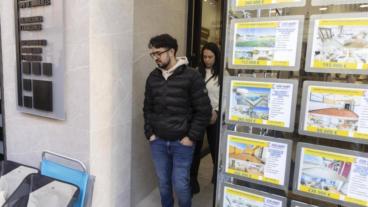 Dos clientes salen de una inmobiliaria de Alzira en una imagen de archivo.