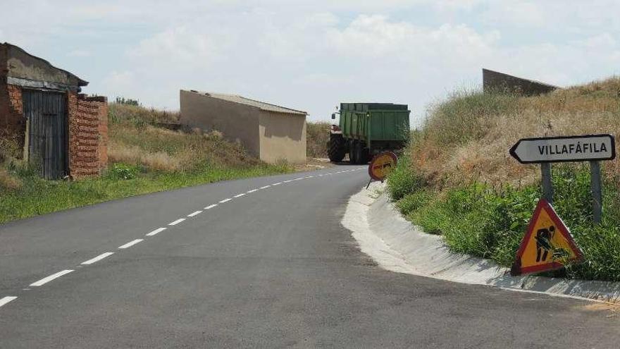 Un tractor circula por el camino, recién asfaltado, de Villaveza del Agua a Villafáfila.