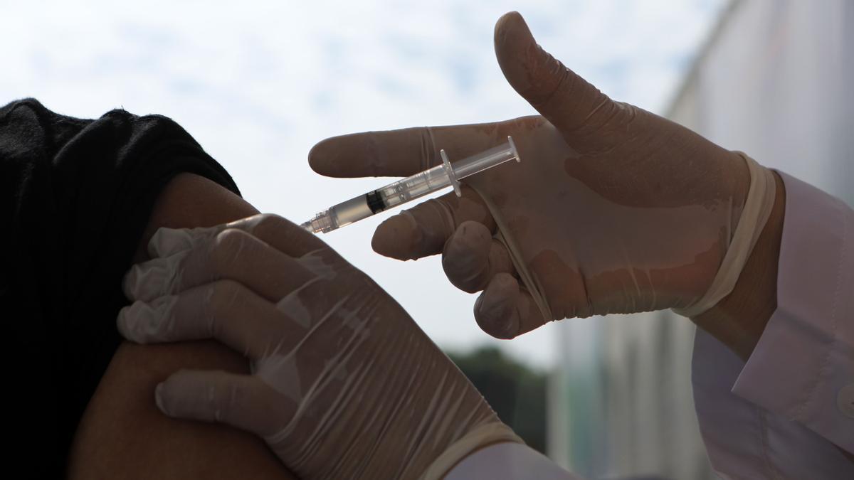 Un sanitario administrando una vacuna contra la covid.