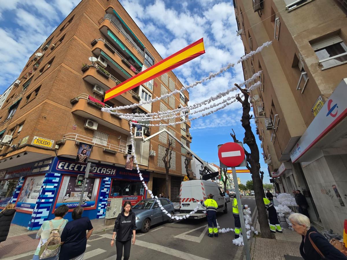 Muchos curiosos han observado cómo instalaban las guirnaldas y las banderas en la calle Toledo de Badajoz.