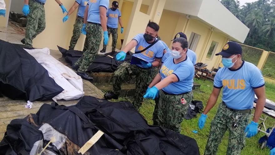 Agentes de policía identifican los cuerpos de fallecidos por la tormenta Megi en Filipinas.