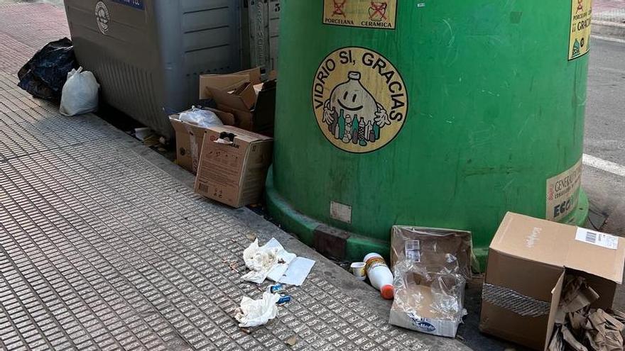 Bolsas de basura y cartones en una calle de Sant Joan junto a contenedores