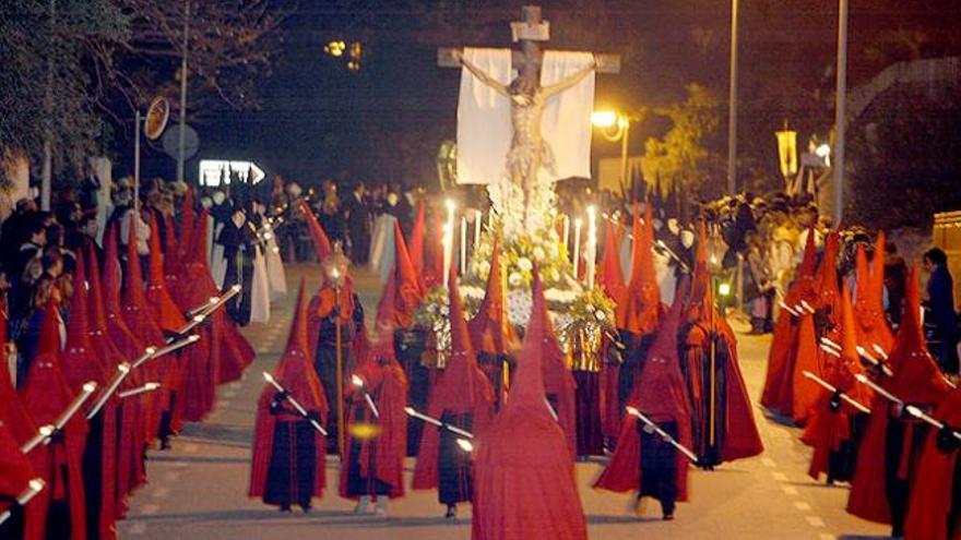 El Cristo de la Oración está acompañado por cofrades con túnica negra y capa roja.