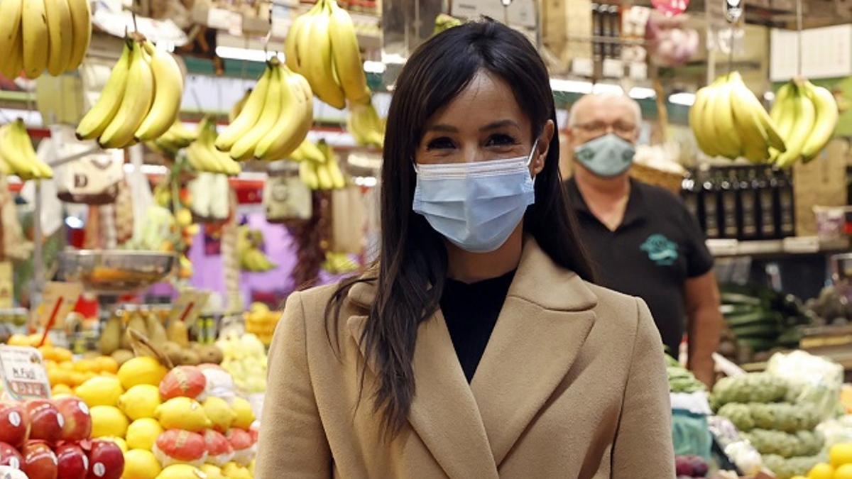 Begoña Villacís con abrigo largo con cinturón en el mercado de Chamberí, en Madrid