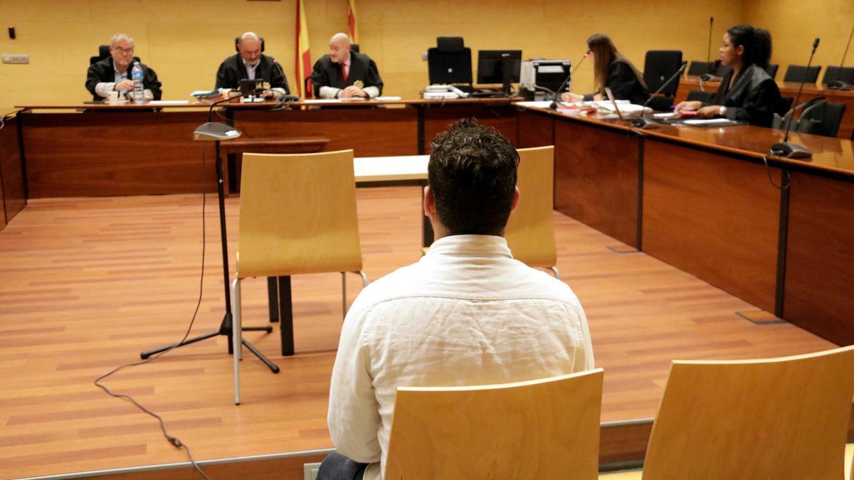 L'acusat, d'esquenes, durant el judici a l'Audiència de Girona.