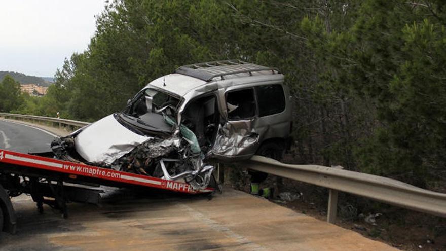 Una grúa retira el coche del fallecido de la carretera.