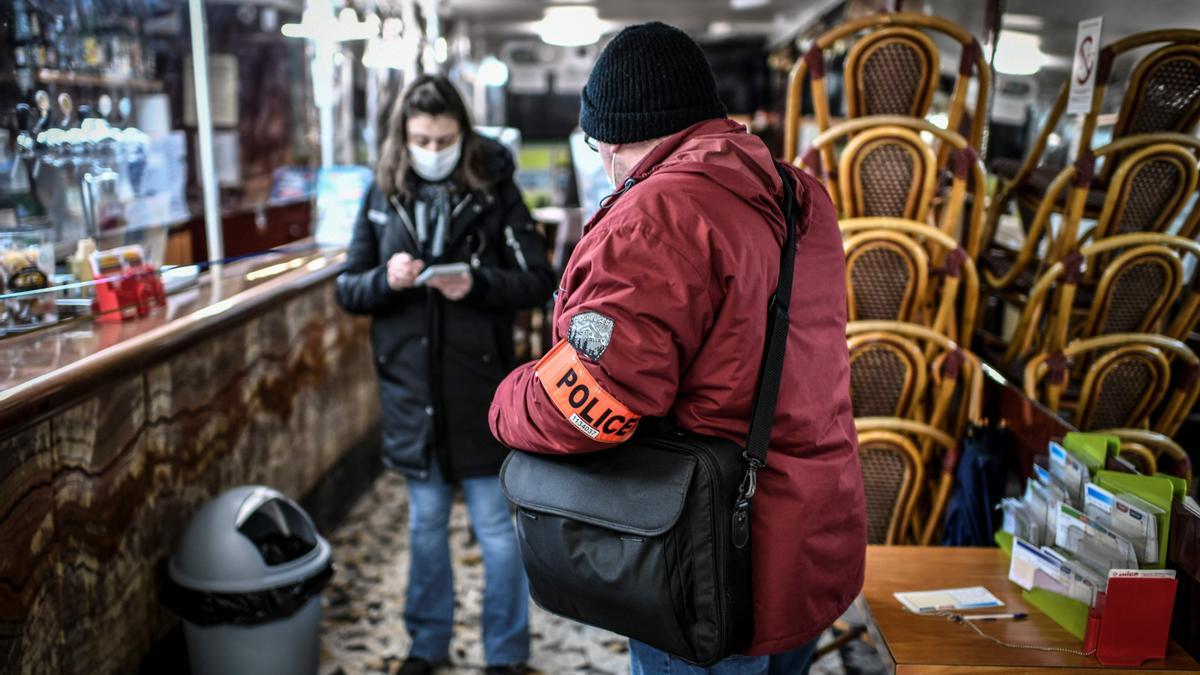 Un inspector de policía realiza un control en un bar de París para vigilar el cumplimiento de las restricciones por la pandemia.