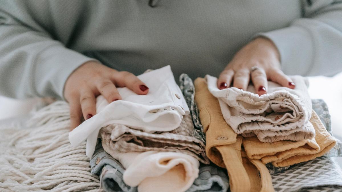 Una mujer coloca la ropa de su bebé.