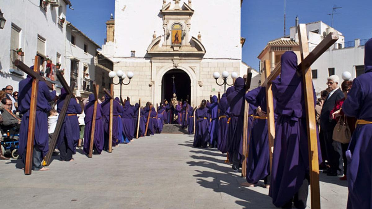 Entrada a la iglesia de Jesús de los Penitentes nazarenos descalzos y con cruces.