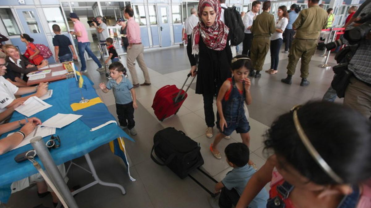 Palestinos con doble nacionalidad abandonan Gaza en el puesto fronterizo de Erez, este domingo.