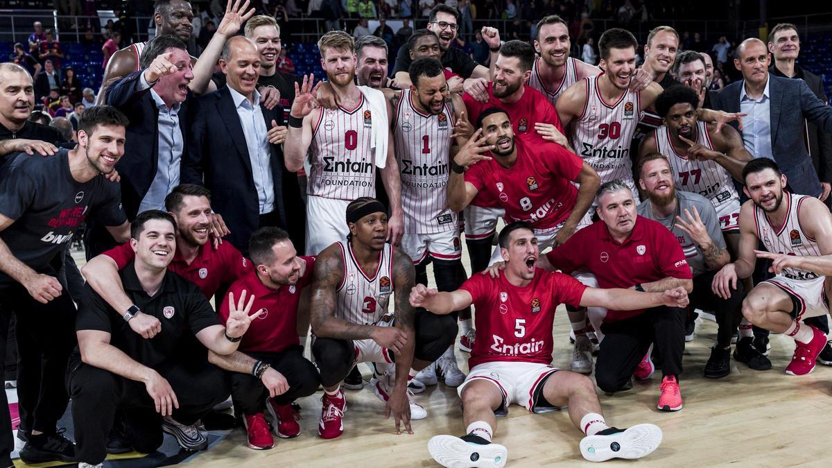 La plantilla del Olympiacos, con técnicos y dirigentes, posan en el parquet del Palau tras la clasificación.