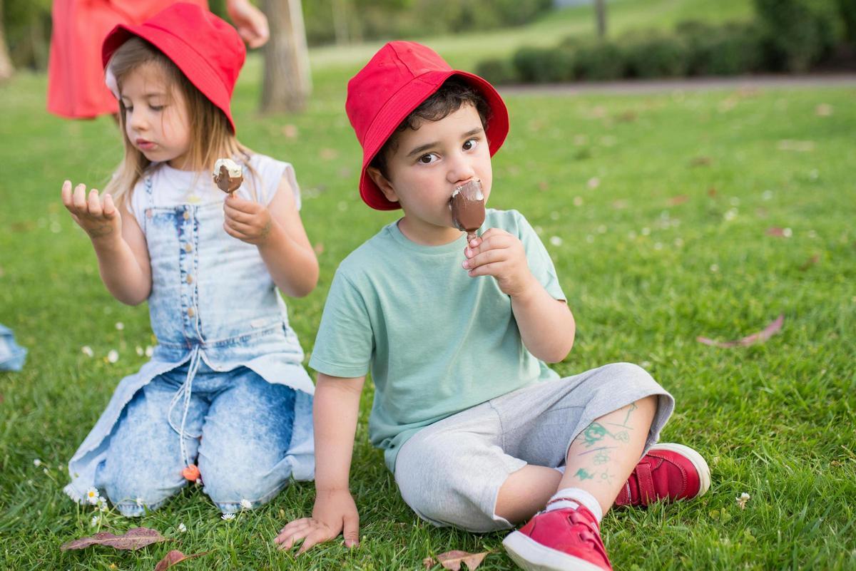 Dos niños con un helado de chocolate.