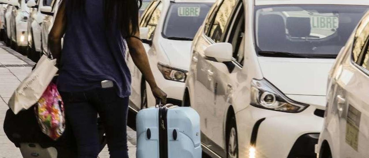 Una mujer se acerca a coger un taxi, ayer, en la parada de la estación de autobuses de Oviedo.