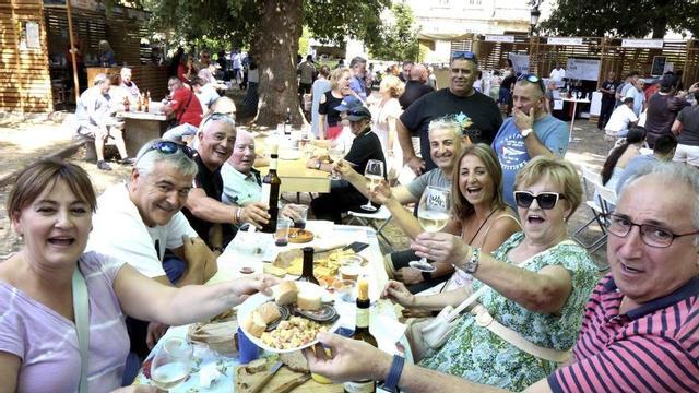 Sobre estas liñas, un grupo de comensais disfruta da lamprea seca en 2025. Á esquerda, asistentes á festa proban o viño de Arbo.   | //D.P.