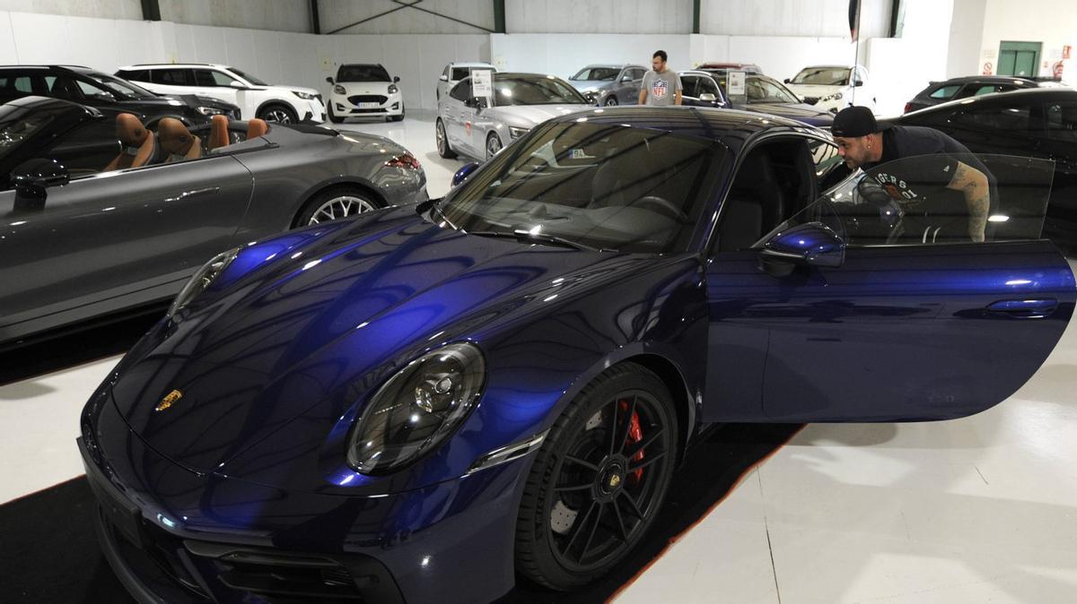 Uno de los visitantes analiza por dentro un Porsche en la feria (arriba). Una limusina que no pasa desapercibida (izquierda). | FOTOS: BERNABÉ/JAVIER LALÍN
