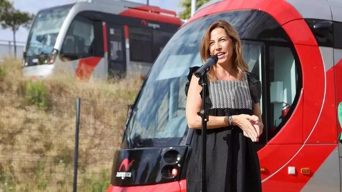 La alcaldesa de Zaragoza, junto a dos convoyes del tranvía.