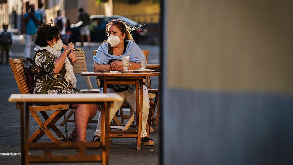 Dos mujeres toman un café en la terraza de un bar de Santa Cruz de Tenerife