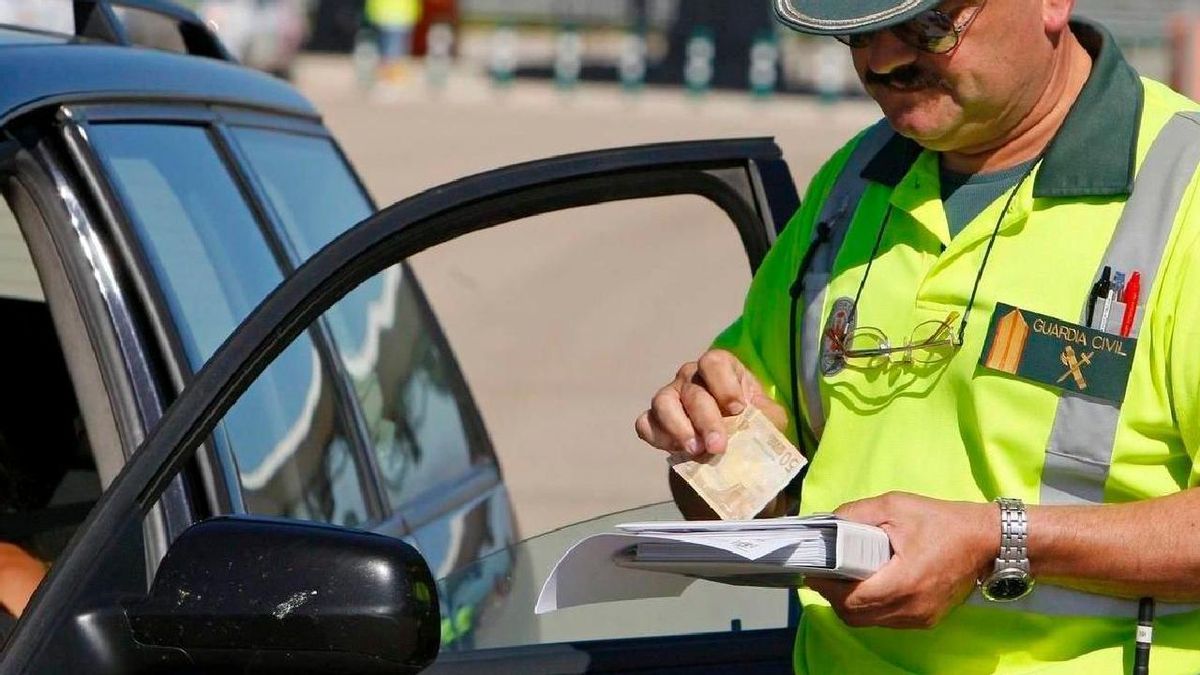 Un agente de la Guardia Civil poniendo una multa