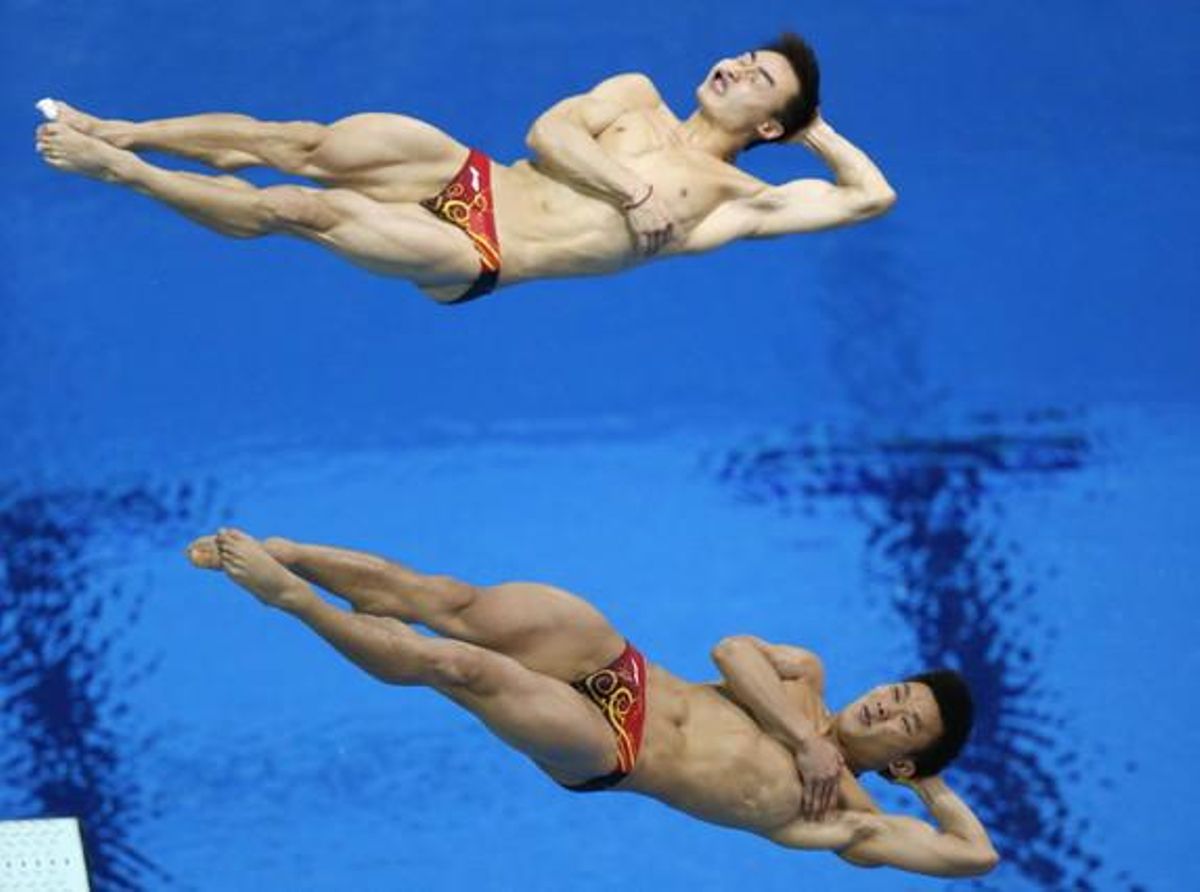 Els saltadors xinesos Kai Qin i Lud Yutong, durant l’execució de l’exercici que els va donar la medalla d’or en trampolí de tres metres sincronitzats.