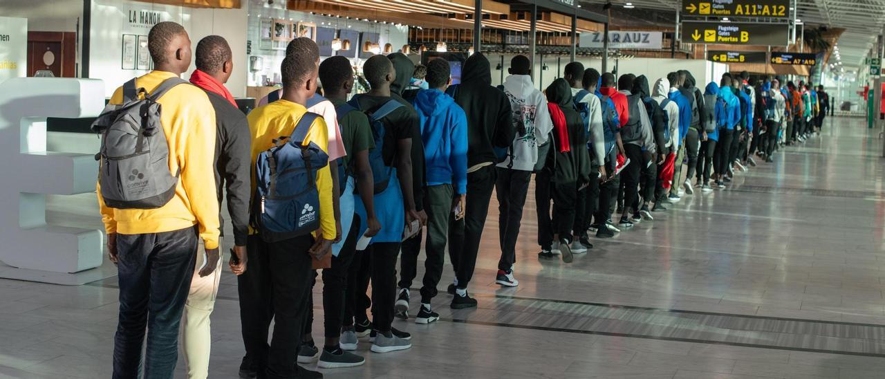 Un grupo de inmigrantes llegados a Canarias espera en el aeropuerto de Fuerteventura a embarcar en un vuelo a la Península, donde serán acogidos en centros de la red del Ministerio de Migraciones.