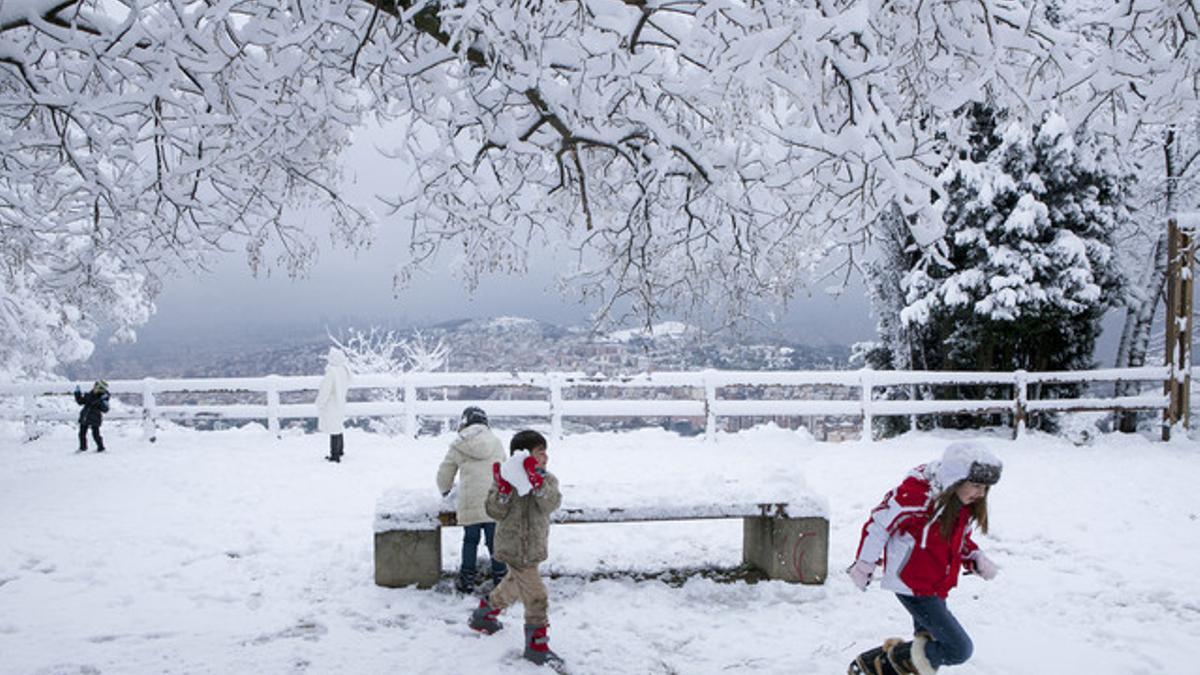 Unos niños juegan con la nieve en la carretera de l'Arrabassada, este sábado.