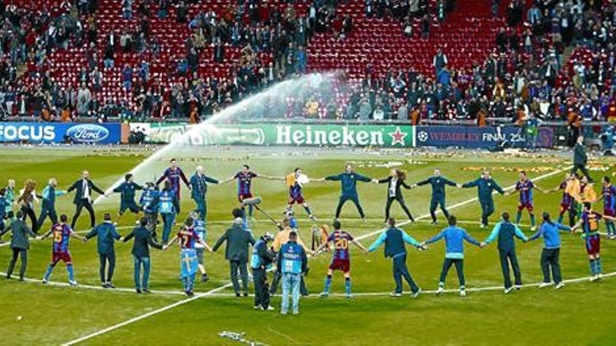 La plantilla azulgrana celebra la Champions con un gran corro en el centro del campo.