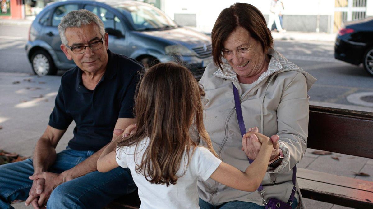 Una niña juega con su abuela en una calle de Vigo.