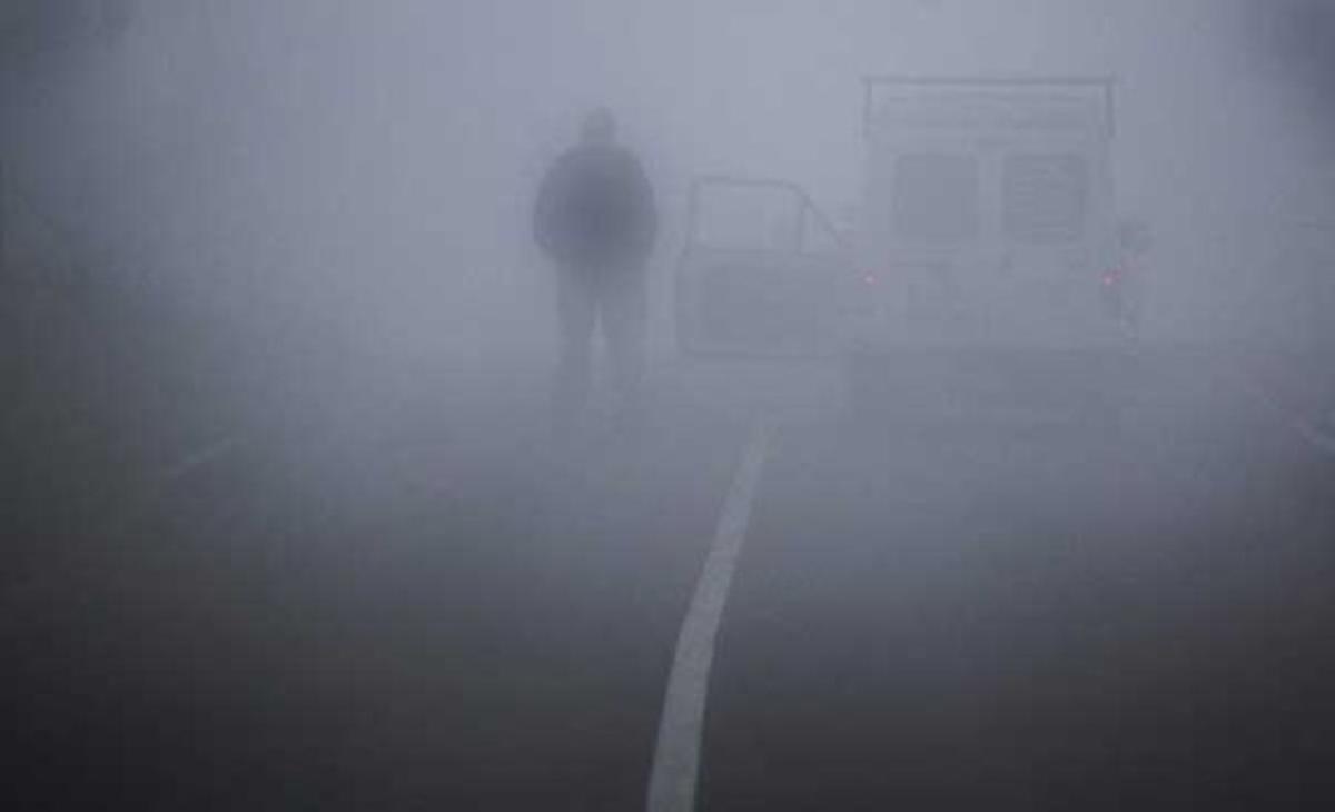 Un home contempla la boira fora del seu cotxe, a prop del riu Rin, a Duisburg (Alemanya).