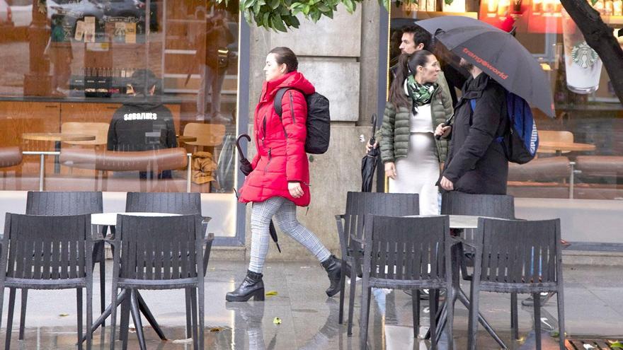 Varias personas pasan por una terraza con veladores vacíos en Sevilla. / E.P.