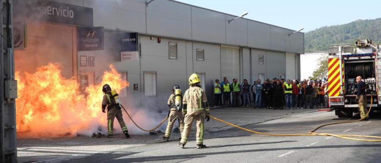 Los bomberos apagan varios contenedores en un concesionario de la carretera de Vigo. |   // FERNANDO CASANOVA