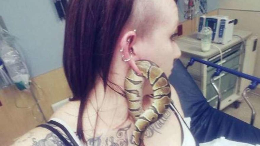 La serpiente Barta, enganchada en la oreja de la joven.